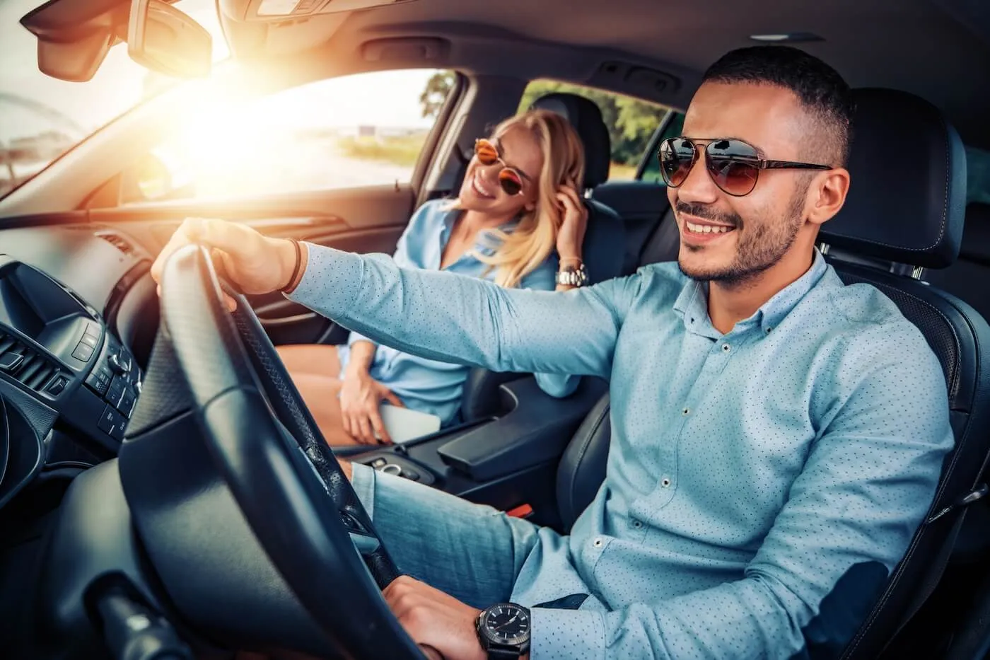Happy young couple driving a car